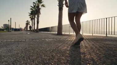 Seksi bacaklı ve kısa elbiseli neşeli bir genç kadın. Gezinti güvertesinde yürüyen mükemmel kadın bacakları.