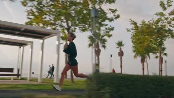 夕阳西下 年轻女子健美运动女子在散步长廊上跑的追踪镜头 高质量的4K镜头 — 图库视频影像