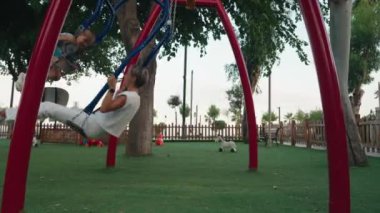 Mutlu anne, küçük oğluyla arka bahçede salıncakta oynuyor. Yüksek kalite 4k görüntü