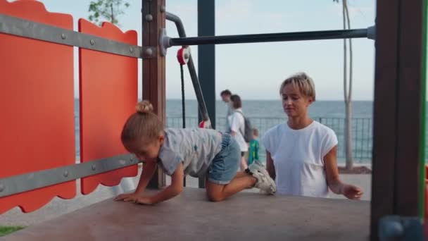 年轻的母亲在操场上抚养她的儿子 孩子们在户外玩耍 孩子们在外面 暑假和假期 高质量的4K镜头 — 图库视频影像