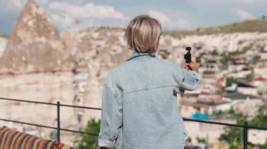 Genç sarışın kadın gezgin blogcu Kapadokya antik şehrinde selfie çekiyor.. 