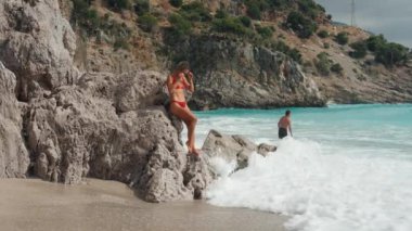 Dışarıda bikinili romantik tutkulu genç bir kız vahşi tropikal deniz geçmişine karşı. İnce sportif, güzel, şehvetli, beyaz bir kadının portresi. Yüksek kalite 4k görüntü