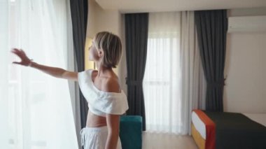 Başarılı bir seyahat yolculuğundan sonra yatağa atlayan mutlu genç bir kadın otel odasında özgürlüğün tadını çıkarıyor. Yüksek kalite 4k görüntü