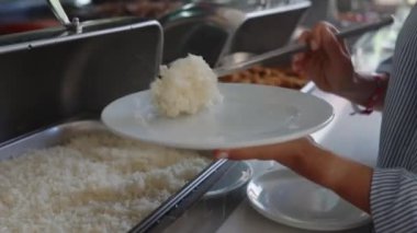 Bir kadın açık büfedeki tabağına yemek koyar. Her şeyi kapsayan hizmet. self servis büfesi. Kadın eli, kadın restorandaki, oteldeki ısıtmalı tepsilerden vejetaryen yemeği alıyor. Yakın plan.. 
