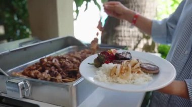 Bir kadın açık büfedeki tabağına yemek koyar. Her şeyi kapsayan hizmet. self servis büfesi. Kadın eli, kadın restorandaki, oteldeki ısıtmalı tepsilerden vejetaryen yemeği alıyor. Yakın plan.. 