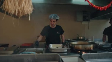 Aşçı, bir restoranda ya da otelde profesyonel bir mutfakta yemek hazırlar. Antalya, Türkiye, 7-2024 Mayıs. Yüksek kalite 4k görüntü