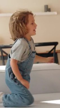 Genç çocuk sıcak ve rahat bir ortamda annesine bir buket çiçek verir. Sevinç ve minnettarlıkla gülümsüyor. Anneler Günü kutlaması ve aile sevgisi kavramı. Orta menzilli doğal ışık