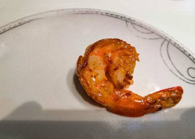 Tabakta tek bir ızgara karides, çıtır çıtır ve altın dokusunu sergiliyor. Yemek blogları, deniz ürünleri lokantası menüleri ya da yemek pişirme dersleri için mükemmel..