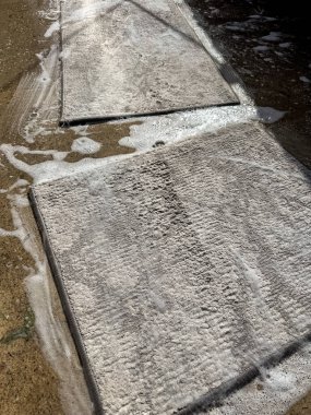 Temizlik sırasında araba paspasları sabun ve suyla kaplanmış. Dokuya, temizliğe ve rutin araba bakımına önem verir. Temizlik, otomotiv veya bakım temaları için elverişli.