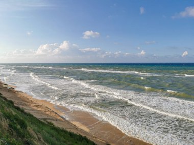 Kumlu kumsalda güçlü dalgaları olan vahşi deniz kıyıları. İnsan yok, sadece doğanın gücü. Özgürlük, yalnızlık, macera ve doğal enerji kavramları için mükemmel bir imaj..