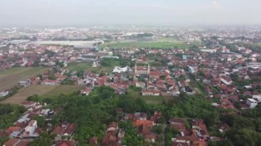 Evleri, yeşillikleri ve yolları olan yoğun nüfuslu bir yerleşim bölgesinin havadan görünüşü.
