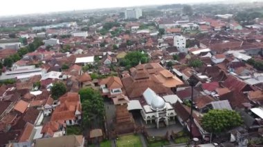 Geleneksel ve modern binaların karışımından oluşan yoğun nüfuslu bir şehir bölgesinin havadan görünüşü, buna gümüş kubbeli bir cami de dahil. Menara Kudus.