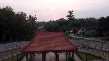 Yeşillik ve evlerle dolu kırsal bir köyde huzurlu bir günbatımı..