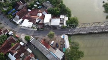 Evleri, yolları ve nehir üzerinde köprüsü olan küçük bir kasabanın havadan görünüşü..