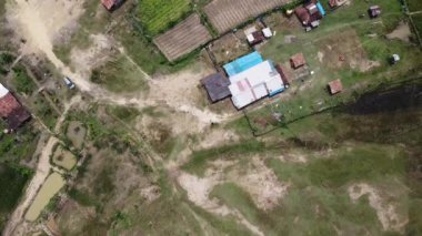 Kesongo çamur volkanı bölgesi, Blora, Endonezya. Dağınık evleri, toprak yolları ve tarım arazileri olan kırsal alan manzarası. Bazı bölgeler yeşil, diğerleri kuru ve çorak görünür..