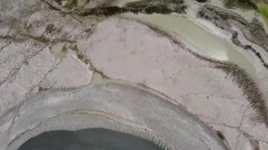 Kesongo çamur volkanı bölgesi, Blora, Endonezya. Yeşil bitki örtüsü ve kahverengi çorak arazili bir arazinin havadan görünüşü. Arazi görülebilir yollar ve bazı kayalık bölgelerle dengesiz görünüyor..
