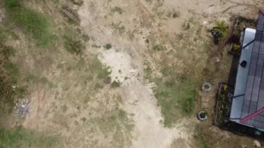 Kesongo çamur volkanı bölgesi, Blora, Endonezya. Çimen parçaları ve sağ tarafında küçük bir yapı olan çorak bir arazinin havadan görünüşü..