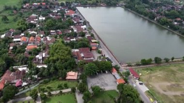 Endonezya, Mojokerto 'da Majapahit kraliyet havuzu. Evler ve yeşilliklerle çevrili büyük dikdörtgen gölü olan bir yerleşim bölgesinin havadan görüntüsü..