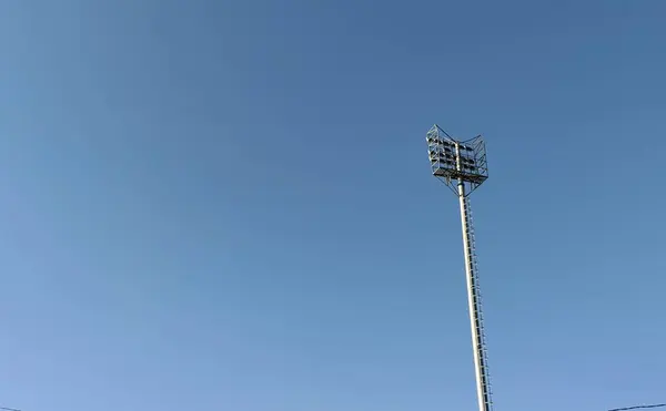 Açık mavi gökyüzüne karşı uzun bir iletişim kulesi. Yapısı ve tasarımı gözler önüne seriliyor..