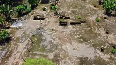 Kerto Mataram İslami Sitesi, Yogyakarta, Endonezya. Yeşillik ve bayrak ile çevrili birkaç dikdörtgen çukurlu arkeolojik kazı alanının hava görüntüsü.