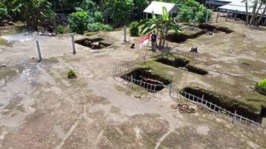 Kerto Mataram İslami Sitesi, Yogyakarta, Endonezya. Yeşilliklerle çevrili bir arkeolojik alanın havadan görünüşü. Sitede kısmen kazılmış dikdörtgen bir çukur var.