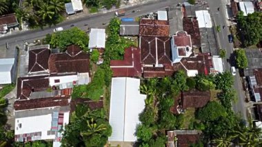 Pleret Arkeolojik Sitesi, Yogyakarta. Yeşillik ve ağaçlarla çevrili, kırmızı çatılı geleneksel evlerin bulunduğu bir yerleşim yeri manzarası..