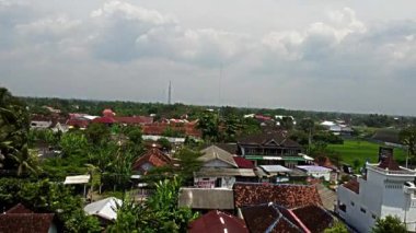 Pleret Arkeolojik Sitesi, Yogyakarta. Bulutlu bir gökyüzünün altında evler, yeşillikler ve tarlaların karışımından oluşan panoramik bir manzara..