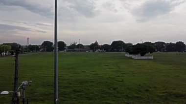 Yogyakarta Sultanlığının kuzey meydanı. Bulutlu bir gökyüzünün altında, arka planda birkaç ağaç ve bina bulunan açık yeşil bir alan. Ön planda uzun bir ışık direği duruyor.