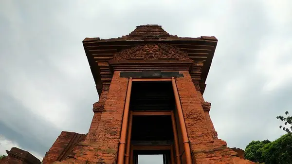 stock image Look up view Bajang Ratu Temple, Mojokerto, Indonesia. This Archaeological site is made of red brick, probably dating from around the mid-14th century. The shape of the building is tall and slender.