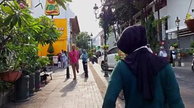 Semarang, Endonezya - 11022022: Başörtüsü takan bir anne ve kızı eski kentin kaldırımında 