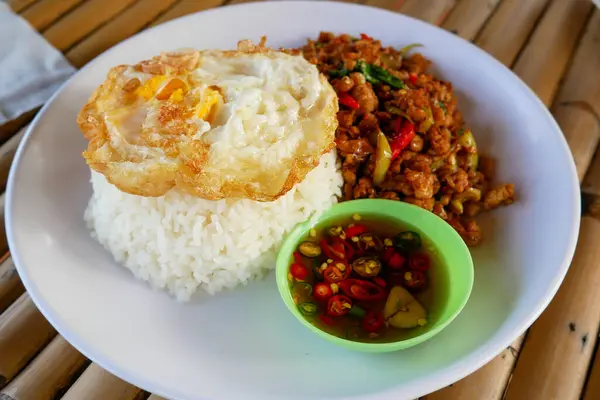 Stock image Stir-fried minced pork with basil and fried egg Popular Thai food menu There was fish sauce chili in a small bowl next to it.