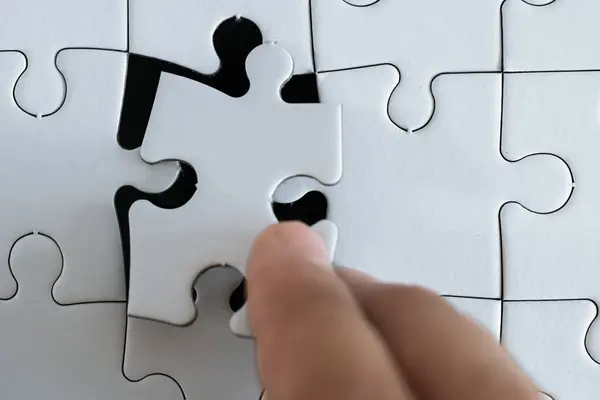 stock image hand placing the last piece of a puzzle 