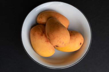 Koyu arkaplanda bir kase mango