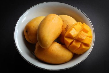 Koyu arkaplanda bir kase mango