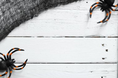 Beyaz ahşap arka planda Cadılar Bayramı örümcek süslemeleri