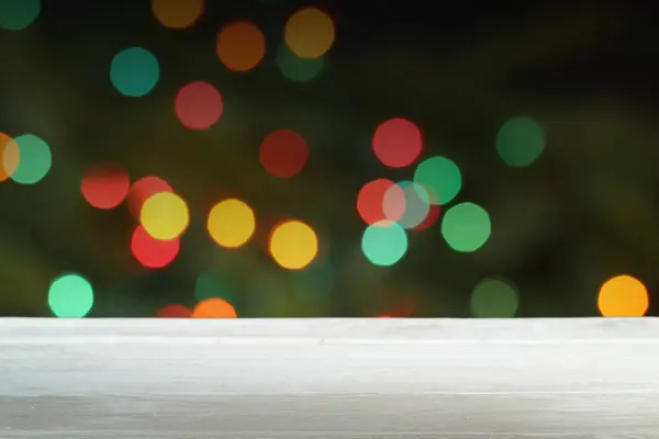 Bulanık Noel ışıklarının önündeki boş ahşap masa.