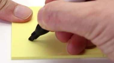 Keskin bir kalemle, beyaz arka planda izole edilmiş yapışkan bir nota yazılmamış.