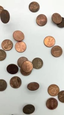 Beyaz yüzeye bir sentlik madeni para düşüyor, yavaş çekimde.