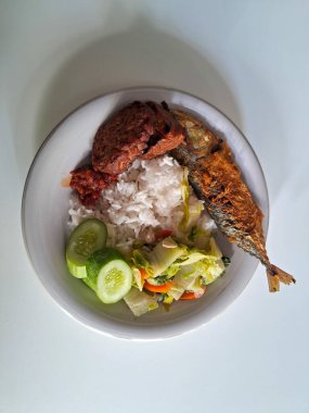 Endonezya geleneksel yemekleri. Pirinç, kızarmış balık, saut hardal yeşili ve tempe bacem..