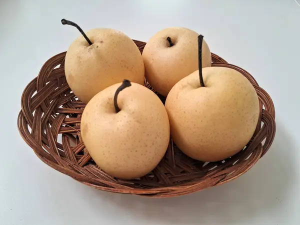 İzole edilmiş beyaz zemin üzerinde dört sarı armut.