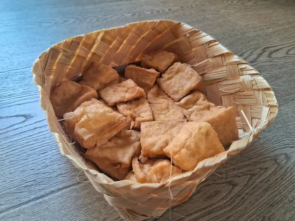 Tahta bir arka planda, turta sepetinde bir grup kızarmış tofu.