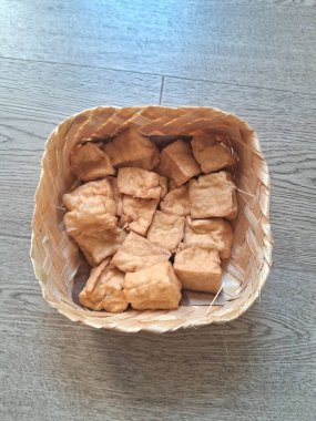 Tahta bir arka planda bambu tabakta kızarmış tofu.