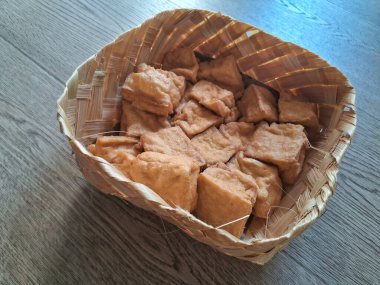 Tahta bir arka planda bambu tabakta kızarmış tofu.