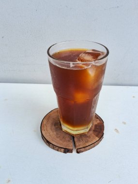 Limonata americano, limonla karıştırılmış beyaz bir arka planda bir bardakta bulunan bir americano.