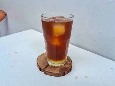 Limonata americano, limonla karıştırılmış beyaz bir arka planda bir bardakta bulunan bir americano.