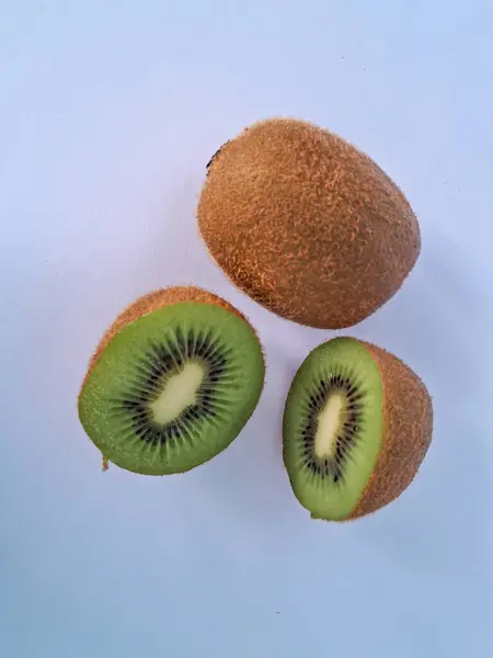 Taze yeşil kivi dilimleri, beyaz arka planda izole edilmiş..