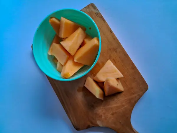 Yeşil bir kasede taze kavun parçaları ve beyaz kasenin dışında izole edilmiş.