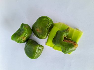 Bugis keki, geleneksel Endonezya aperatifi yumuşak yeşil yapışkan pirinç un keki, tatlı rendelenmiş hindistan cevizi ile doldurulmuş, muz yapraklarına sarılmış, ahşap bir tabakta, beyaz bir arka planda izole edilmiş