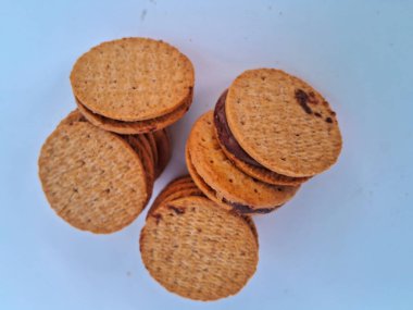 Nefis sandviç bisküvileri, kremalı çikolata dolgulu, mükemmel istiflenmiş ve tatlı bir atıştırmalık için hazır, beyaz bir arka plan izole edilmiş.