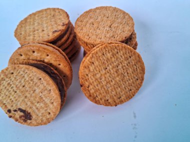 Nefis sandviç bisküvileri, kremalı çikolata dolgulu, mükemmel istiflenmiş ve tatlı bir atıştırmalık için hazır, beyaz bir arka plan izole edilmiş.